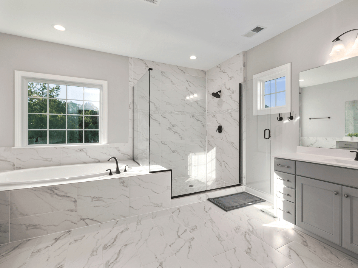 A luxury white marble bathroom filled with natural light.